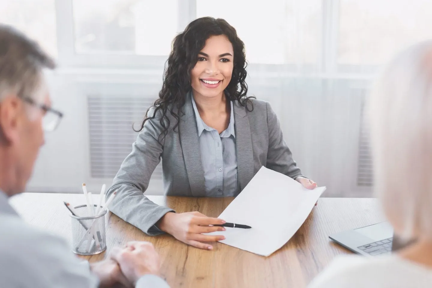 Loan originator meeting with clients at a desk